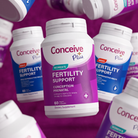A bottle of Conceive Plus Fertility Support dietary supplement centered against a purple background, surrounded by multiple floating bottles of the same product in different colors and angles.