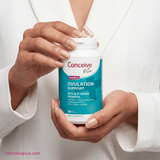 Person holding a container of Conceive Plus ovulation support supplement.